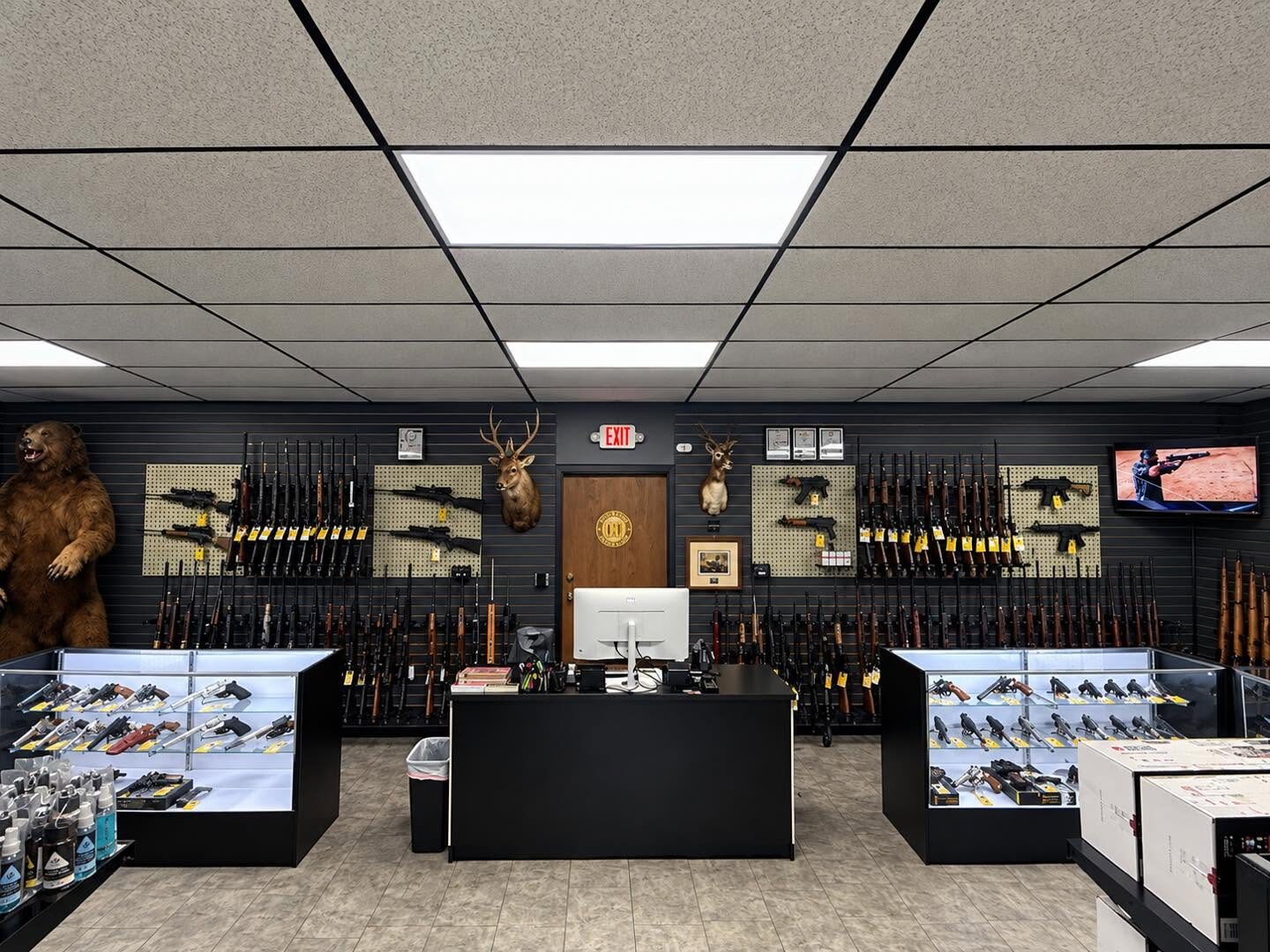 Inside The Armored Vault in Rogers: rifle wall, handgun cases, and the front counter